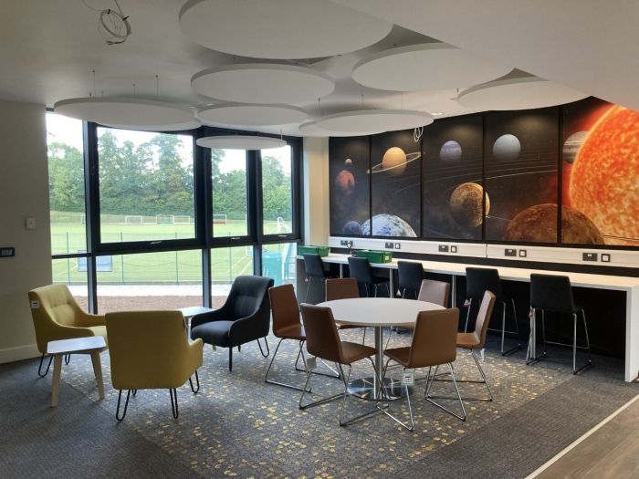 Princethorpe College, a room with tables and chairs and a painting of planets on the wall