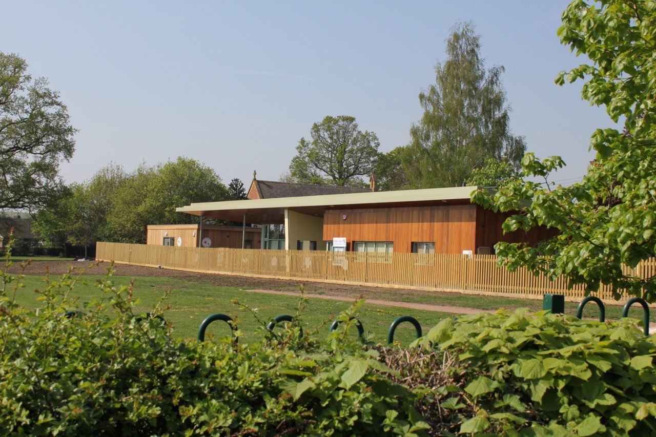A house with a wooden fence around it is surrounded by trees