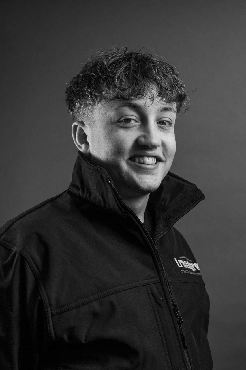 Jack Henderson, a young man in a black jacket is smiling in a black and white photo.