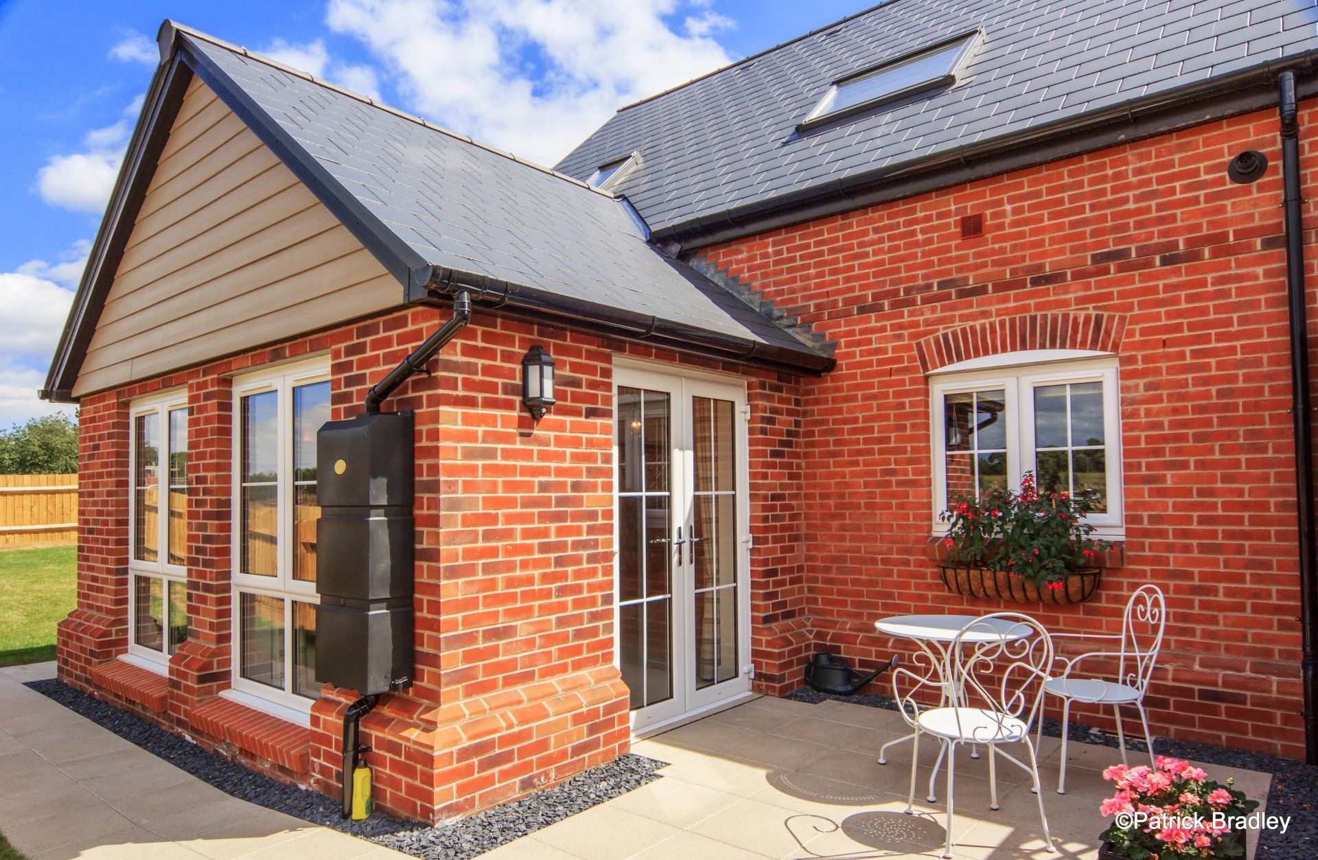 Limetree Village, a brick house with a table and chairs on the patio