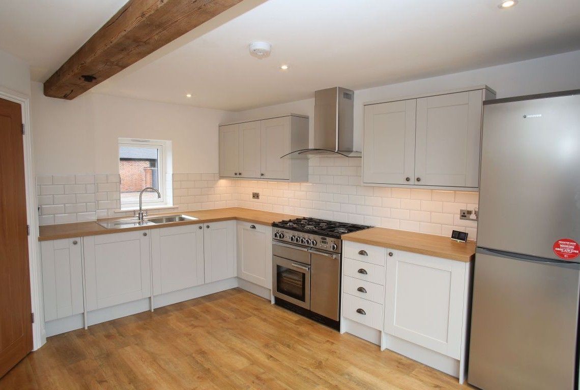 Newbold Farm,  A kitchen with white cabinets , a stove , a refrigerator , and a sink.