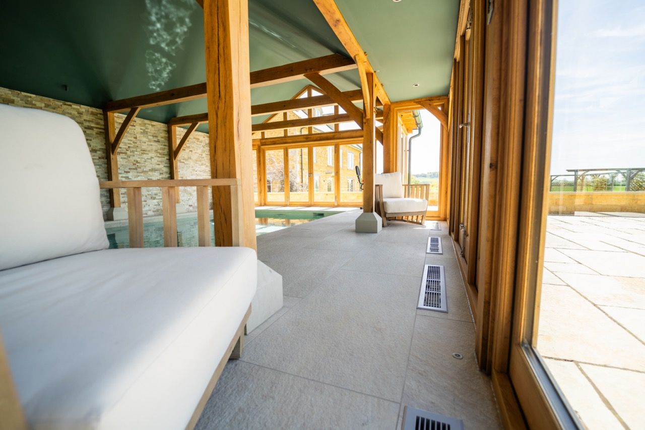 St Dennis Pool House, A large room with a lot of windows and a couch.