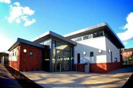 Stoke Park, a large white and brick building with a blue sky in the background