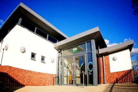 Stoke Park, a white building with a brick wall and a large glass door