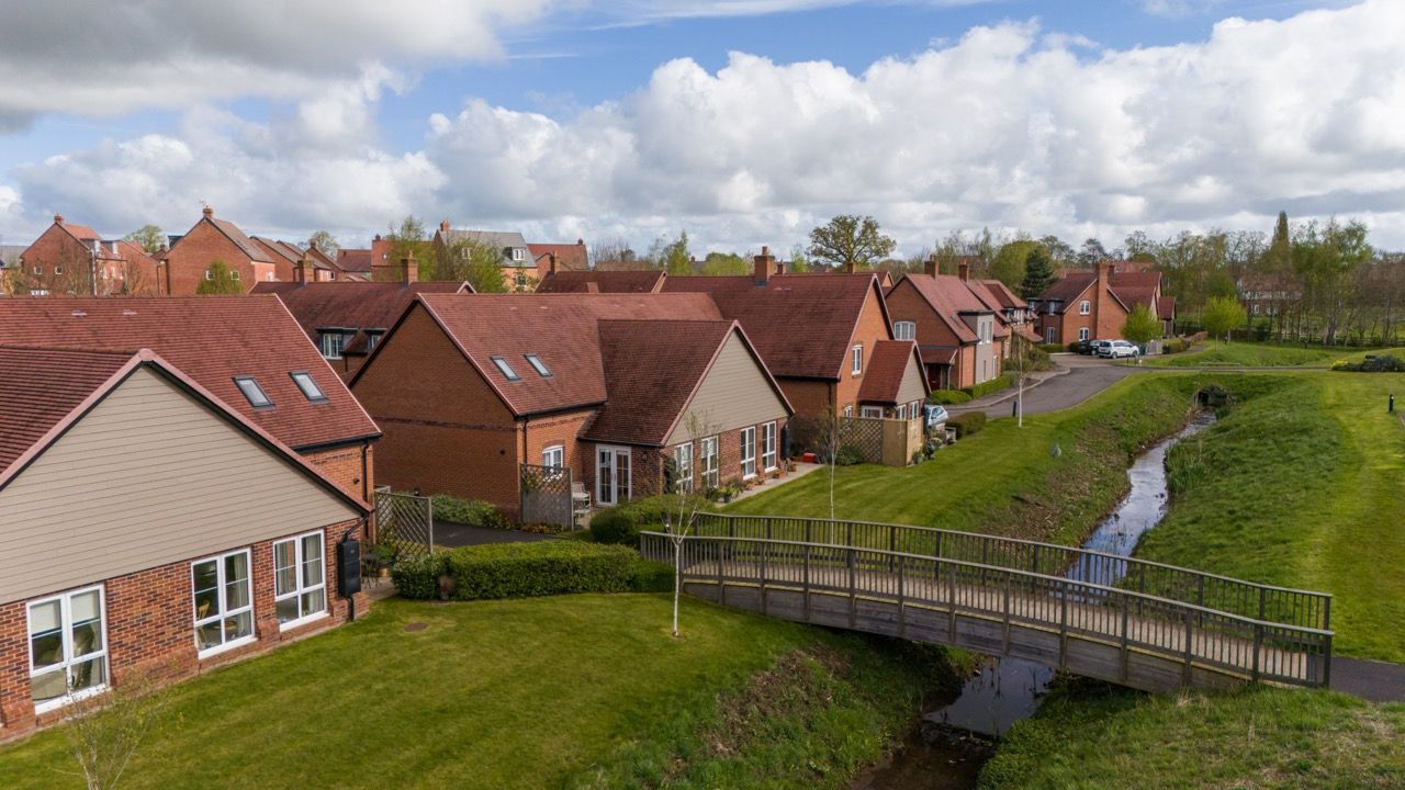 Limetree Village, an aerial view of a residential area with a bridge over a stream.