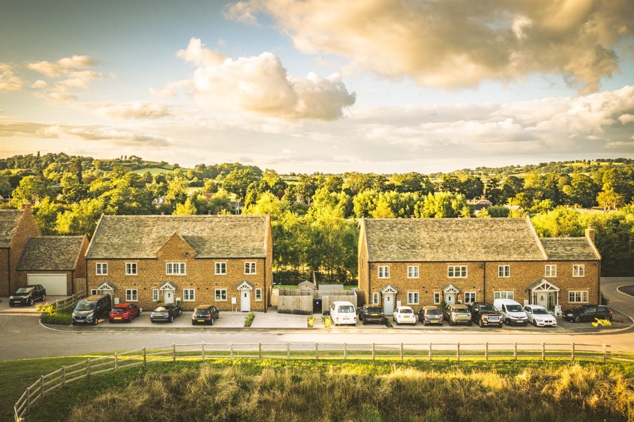 Brailes, An aerial view of a row of houses with cars parked in front of them.