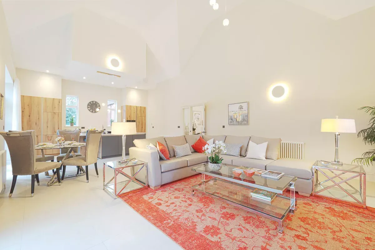 A living room with a couch , coffee table , chairs and a rug.