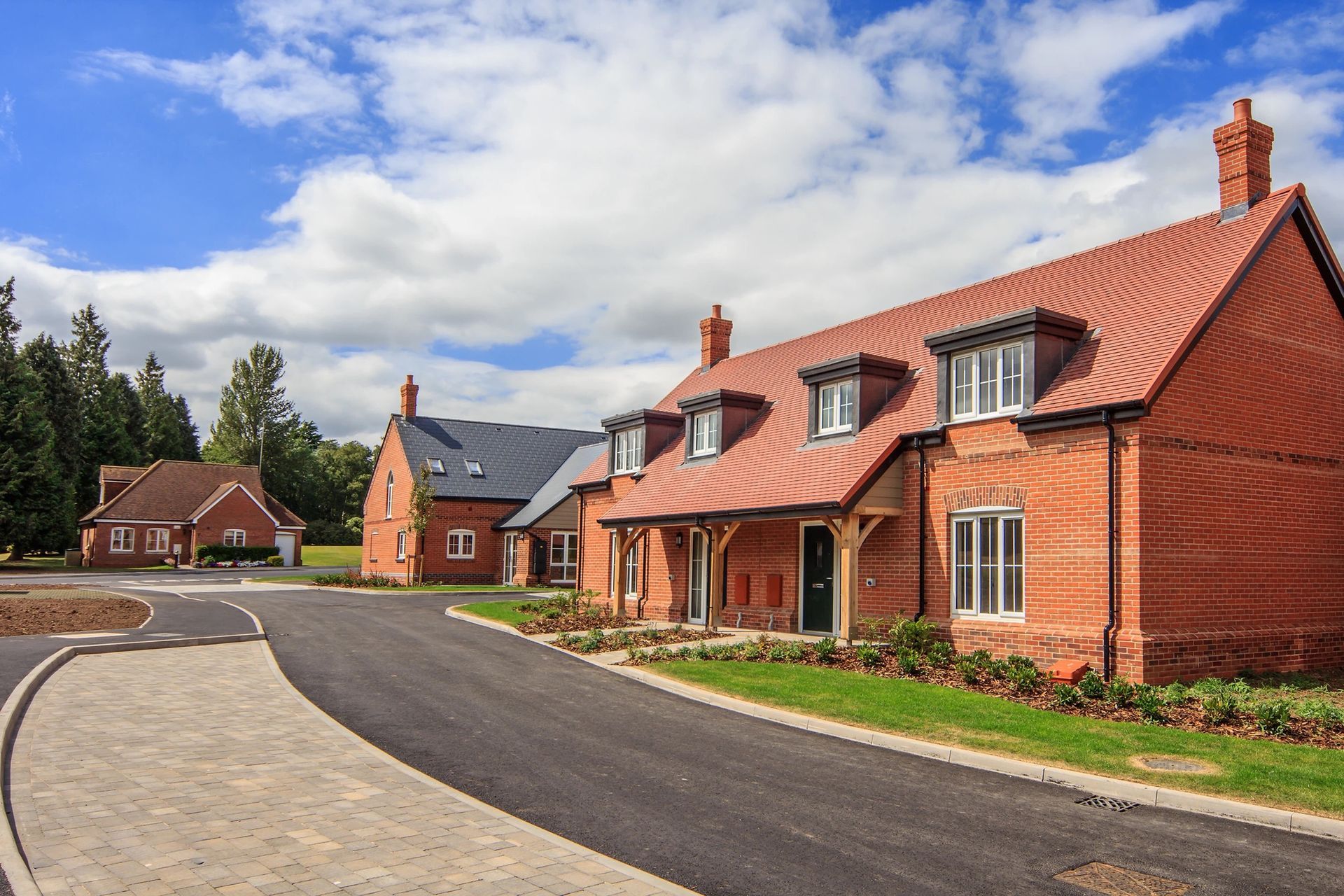 Lime tree village, A row of brick houses sitting next to each other on a sunny day.