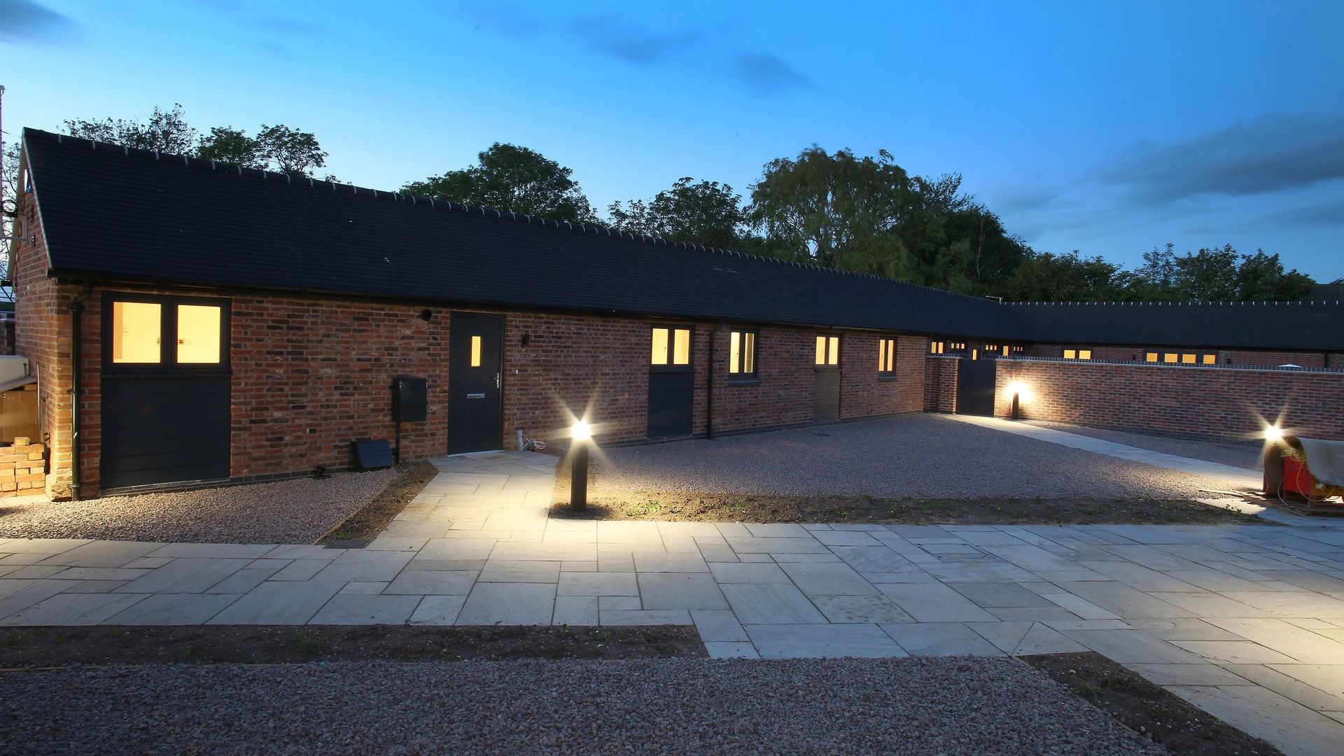 Newbold Farm, A row of brick buildings are lit up at night