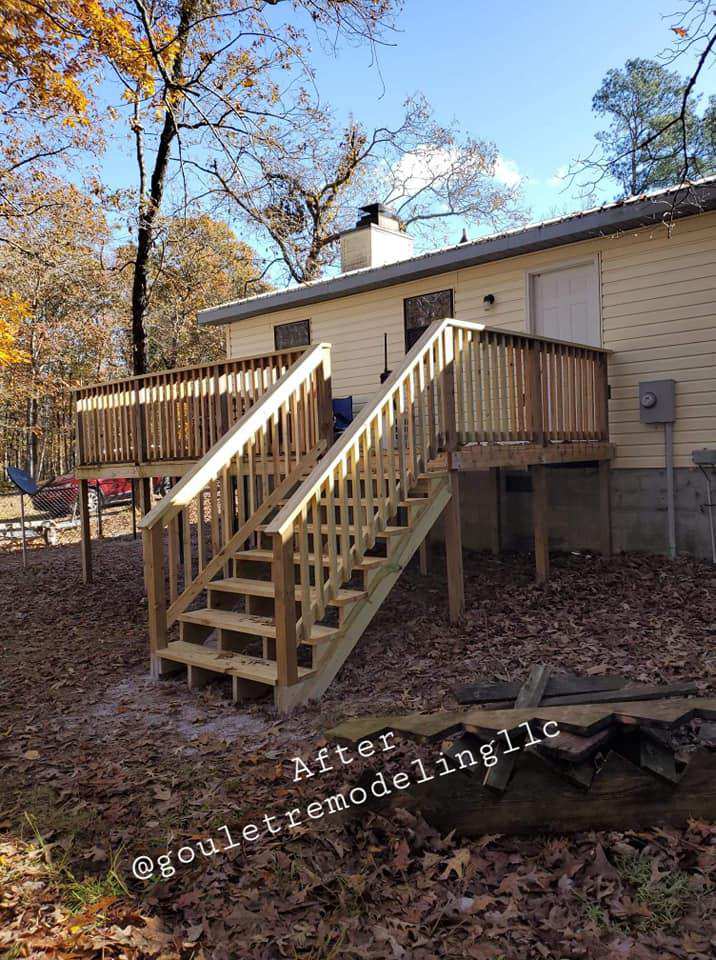 A mobile home with a wooden deck and stairs.