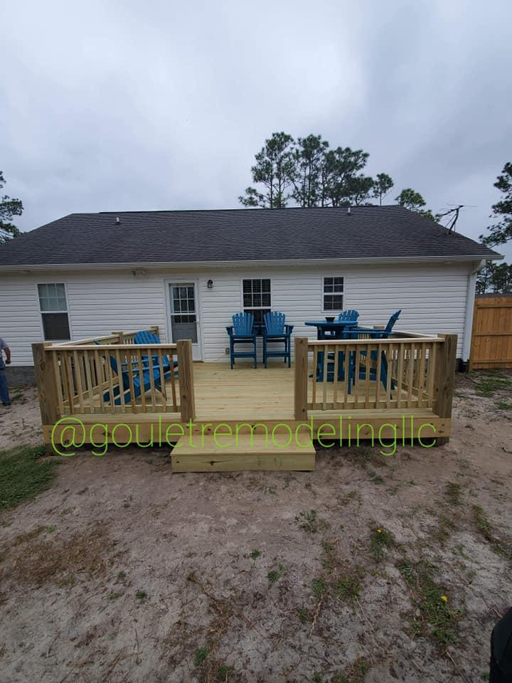 A house with a wooden deck in front of it