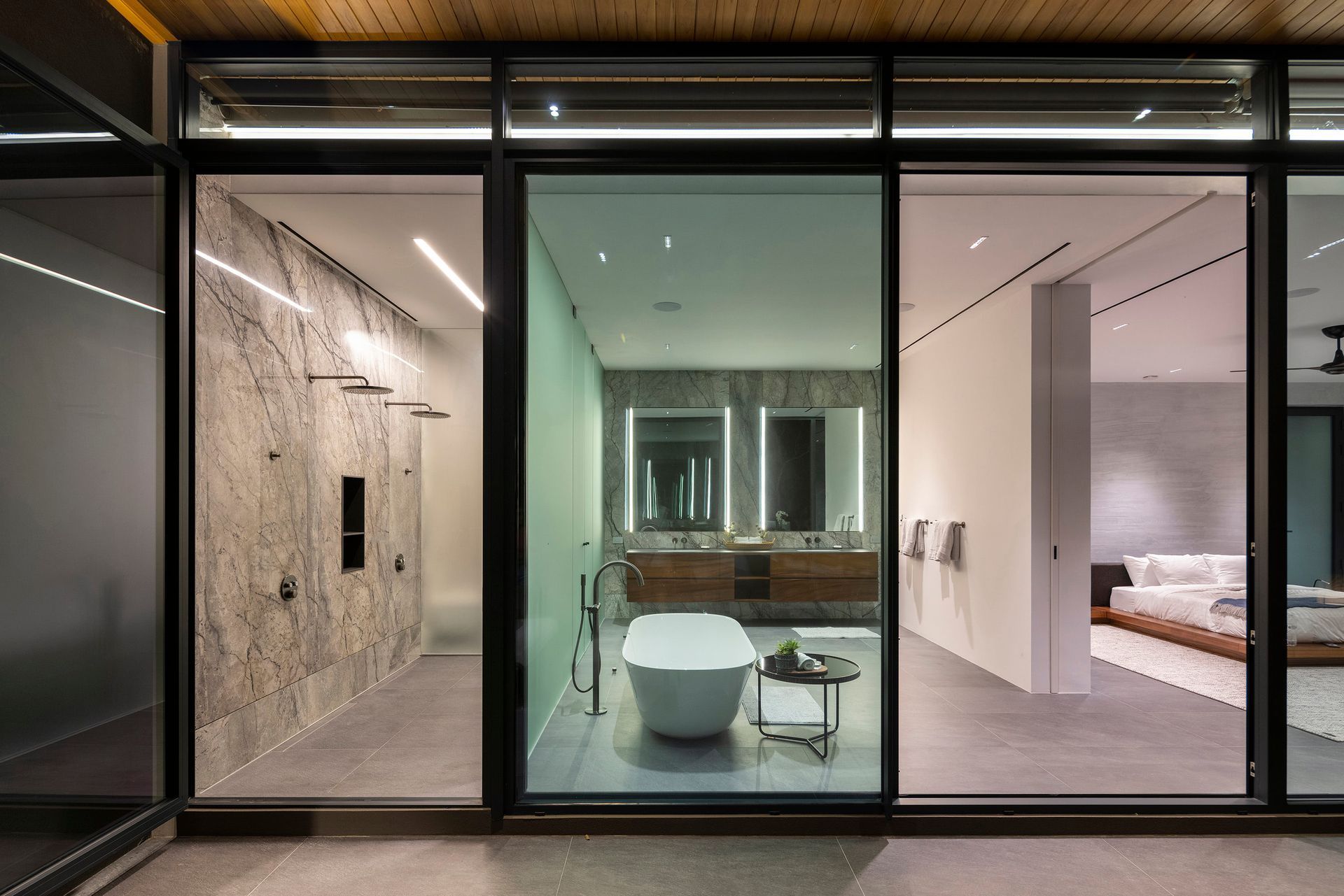 A bathroom with a bathtub and a shower through a large window - in a luxurious SARCO house