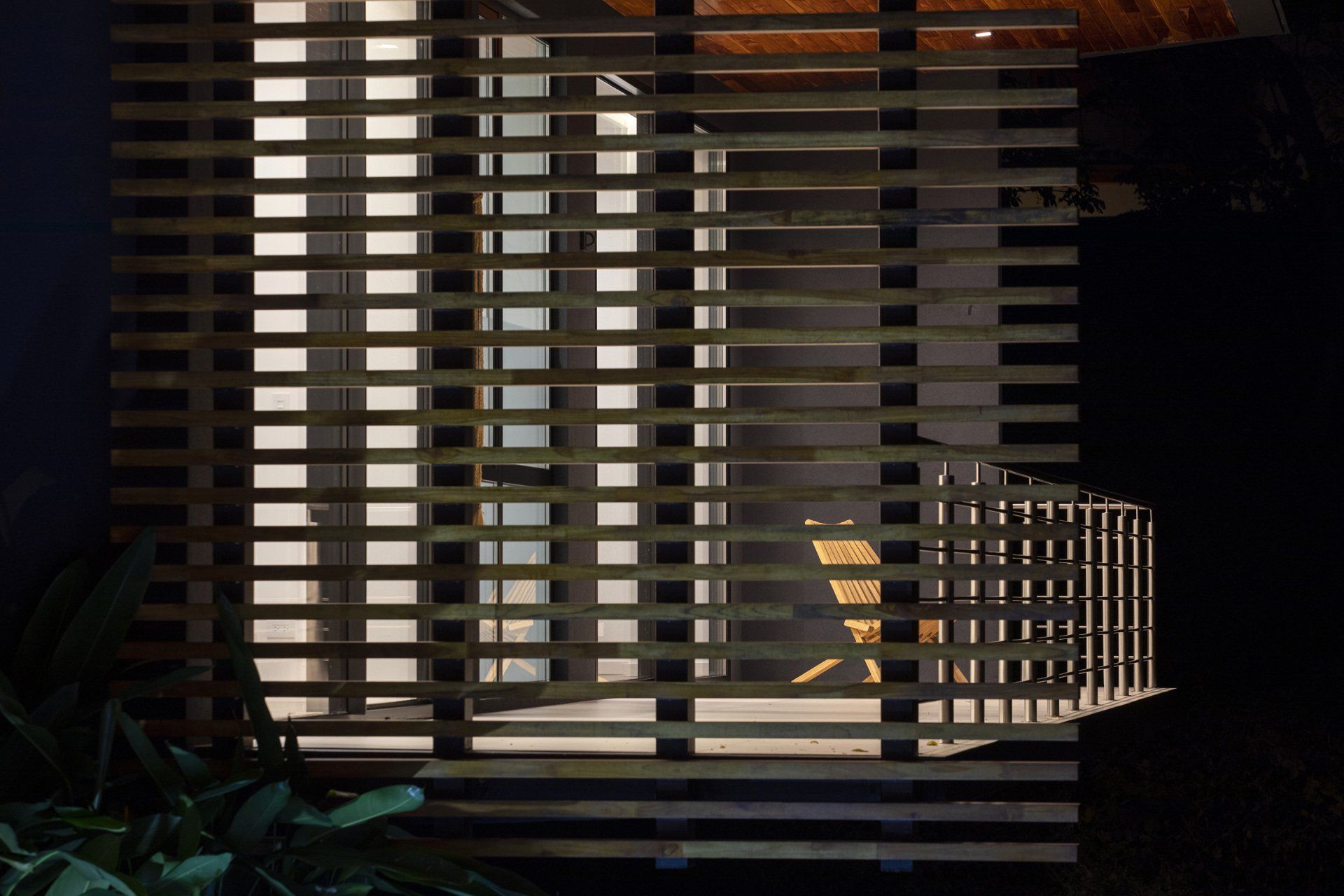 a wooden fence is visible through a window in a dark room . - casa aramara by sarco