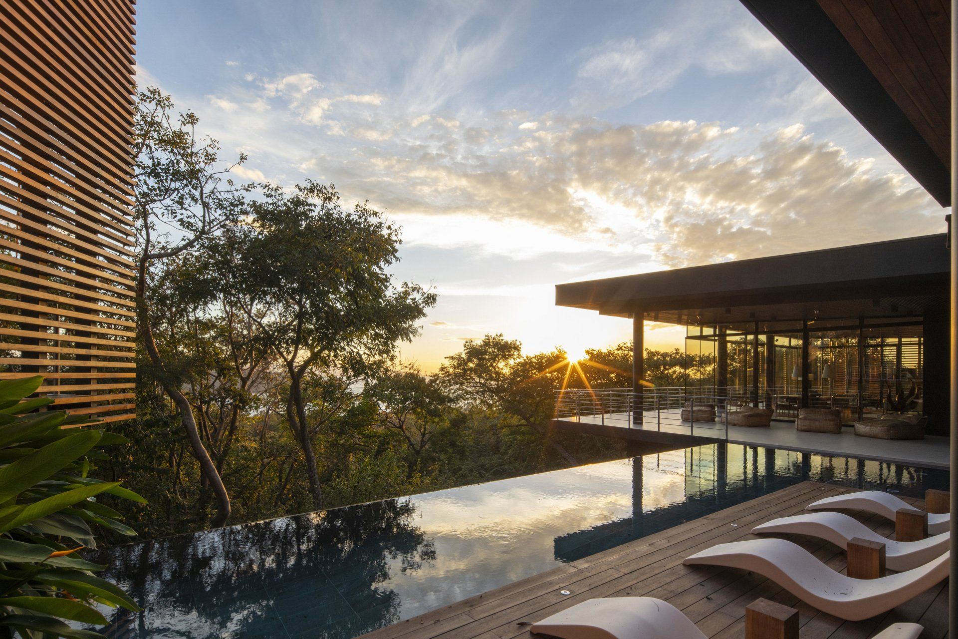 a large swimming pool is surrounded by chairs and trees .