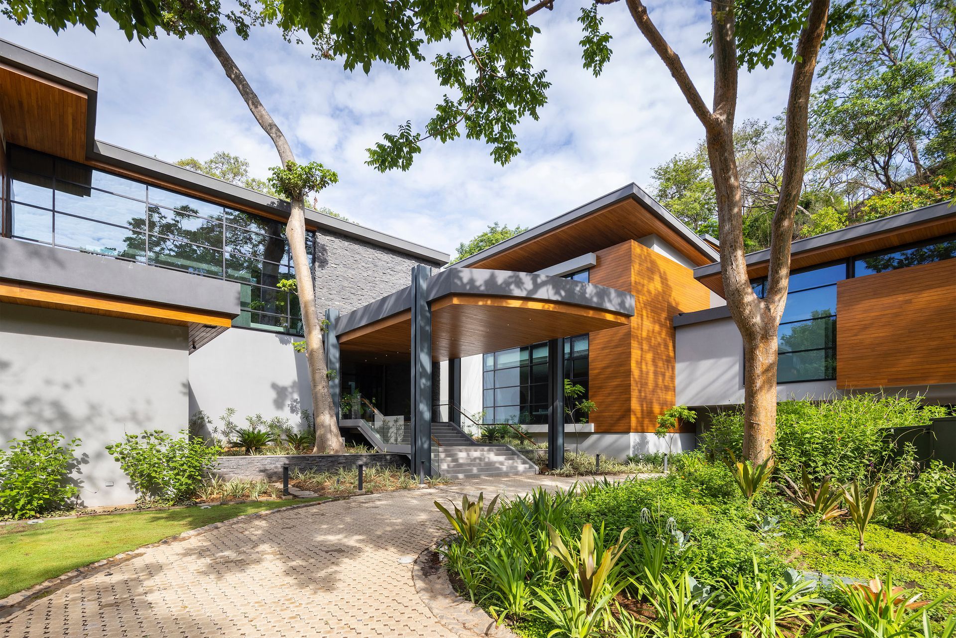 a large house with a lot of windows and trees in front of it .