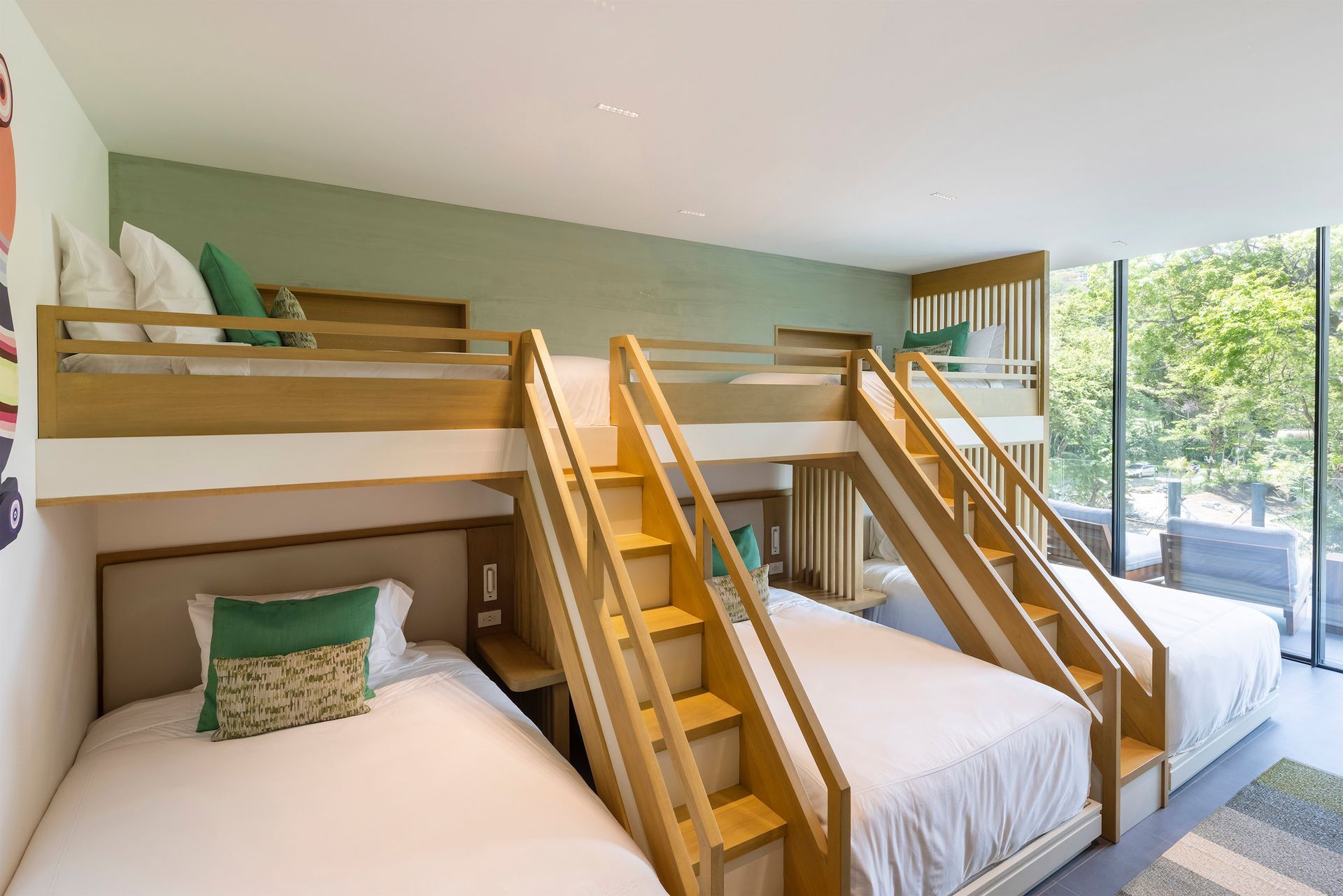 a bedroom with three bunk beds and stairs leading up to them .