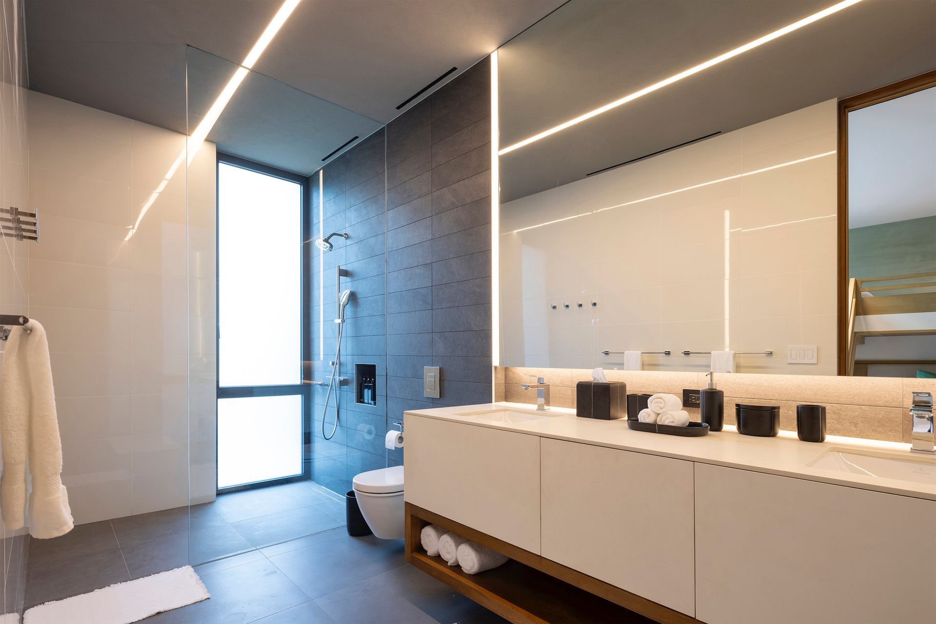 a bathroom with two sinks , a toilet , and a large mirror .