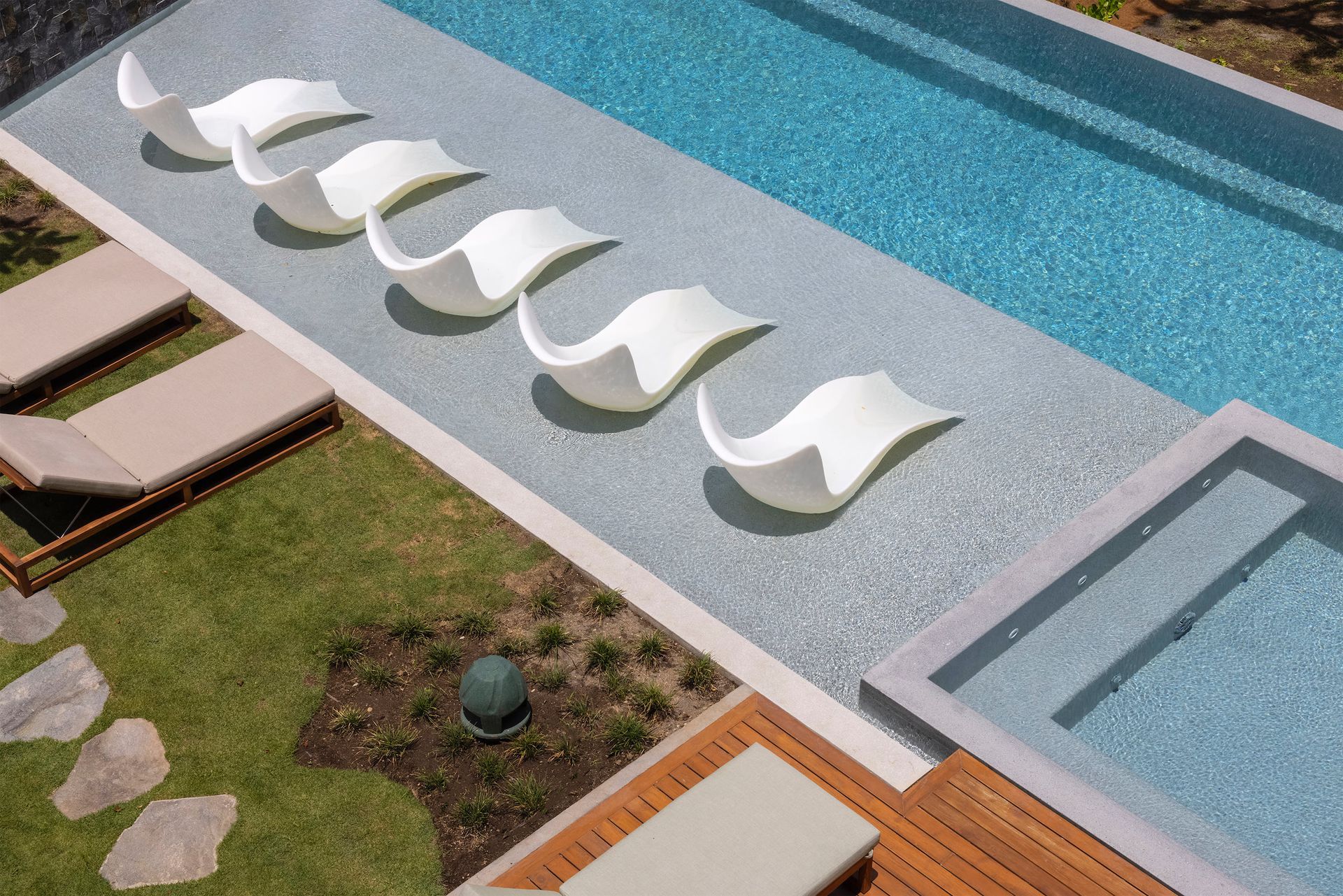 a row of white lounge chairs are lined up next to a swimming pool .