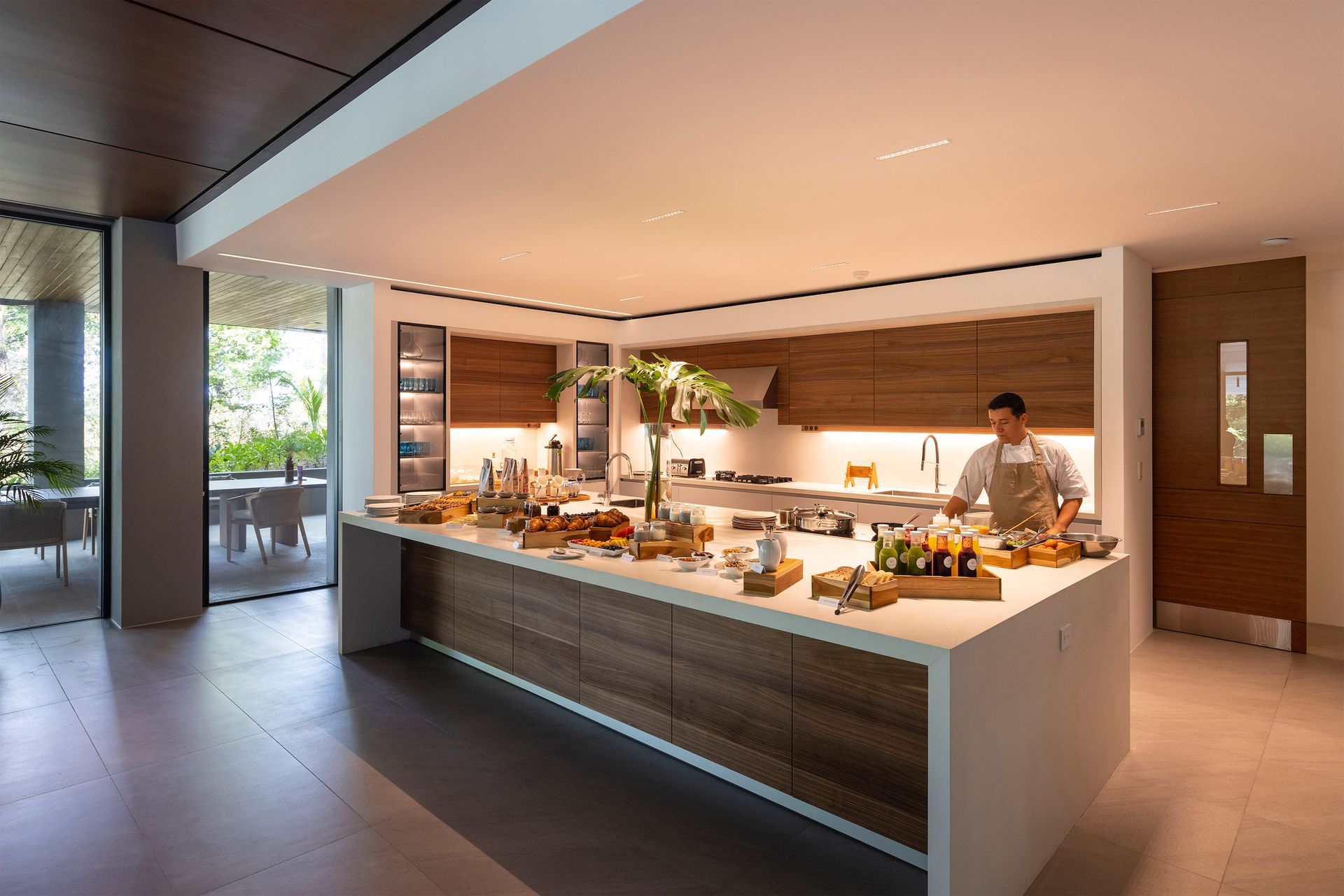 a man is standing in a kitchen preparing food .