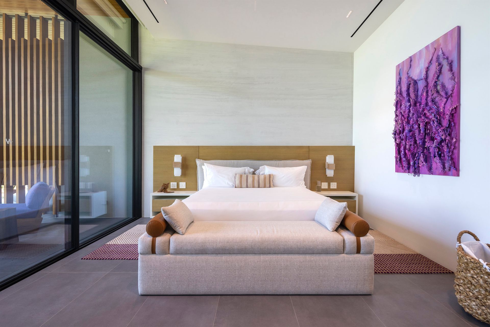 a bedroom with a large bed and a purple painting on the wall .