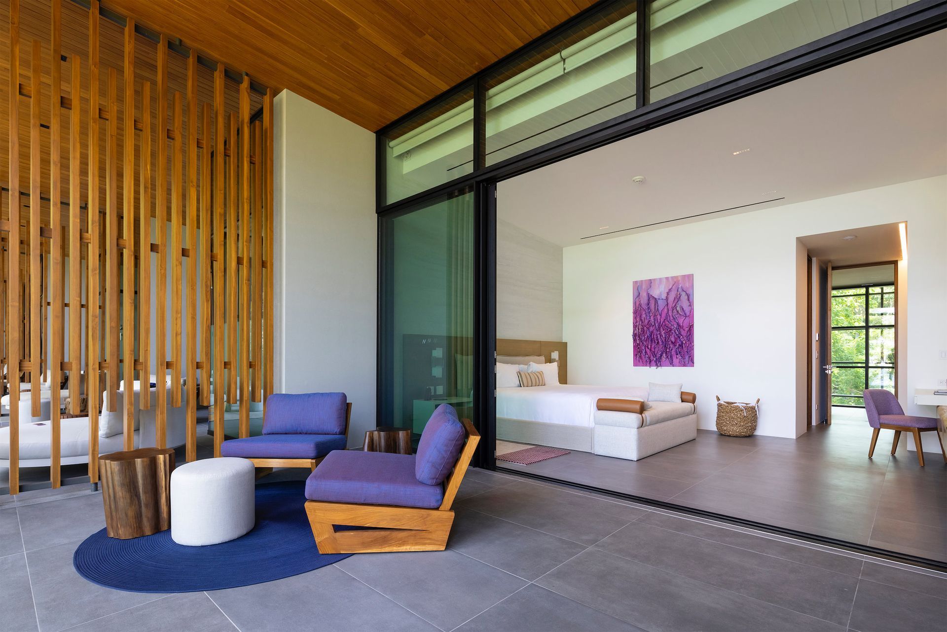 a living room with purple chairs and a bed