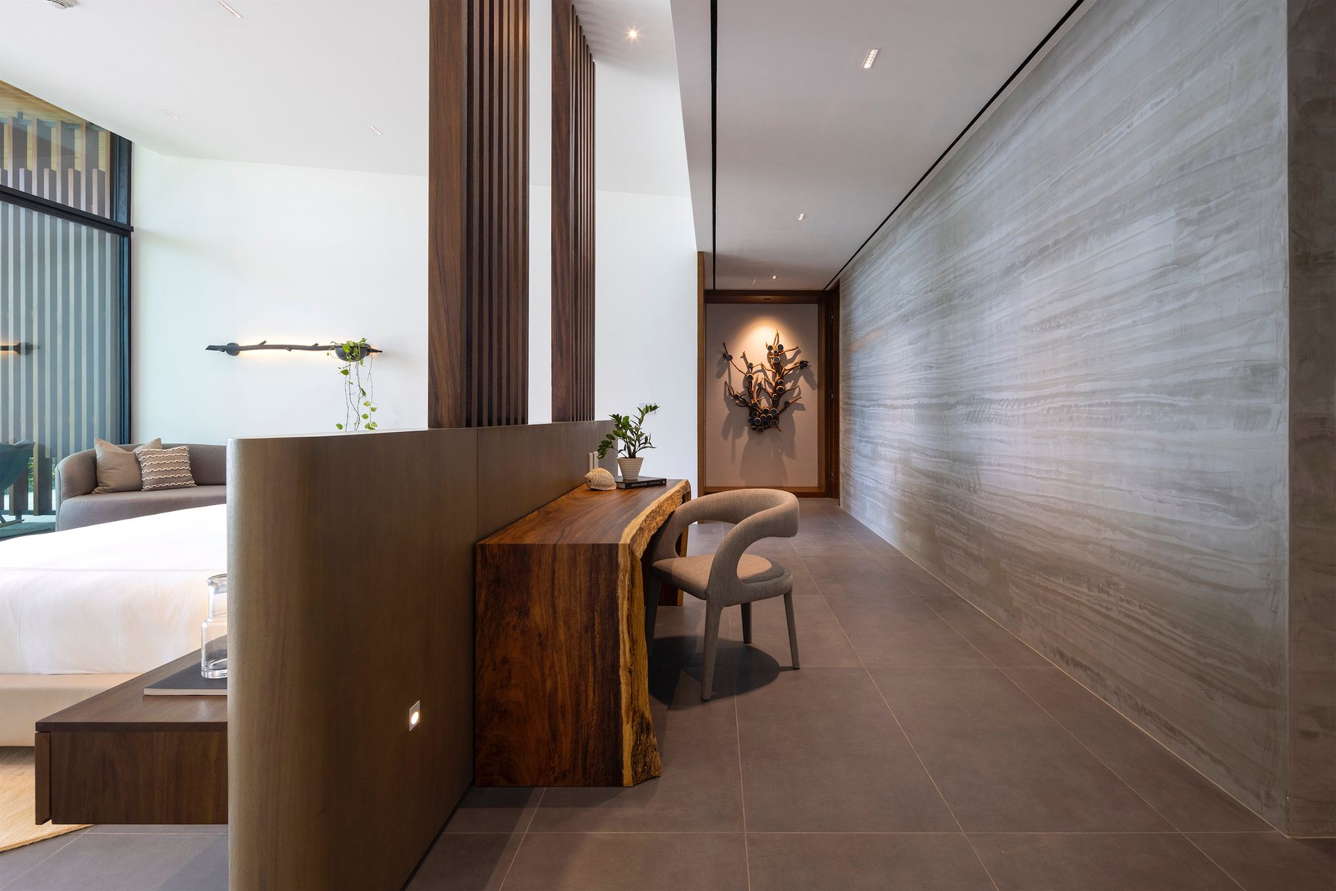 a long hallway with a wooden desk and chairs in a hotel room .