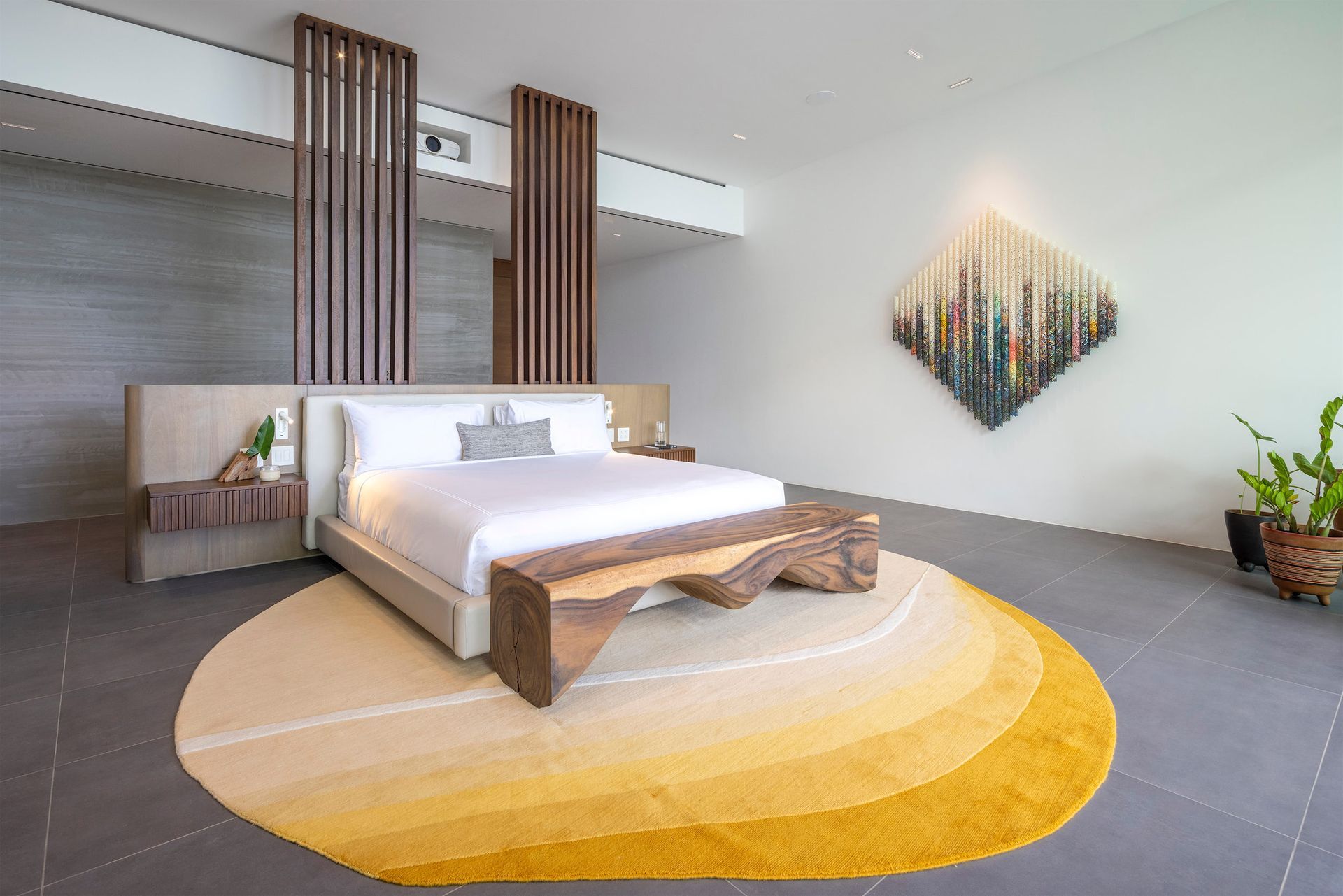 a bedroom with a bed , bench , rug and painting on the wall .