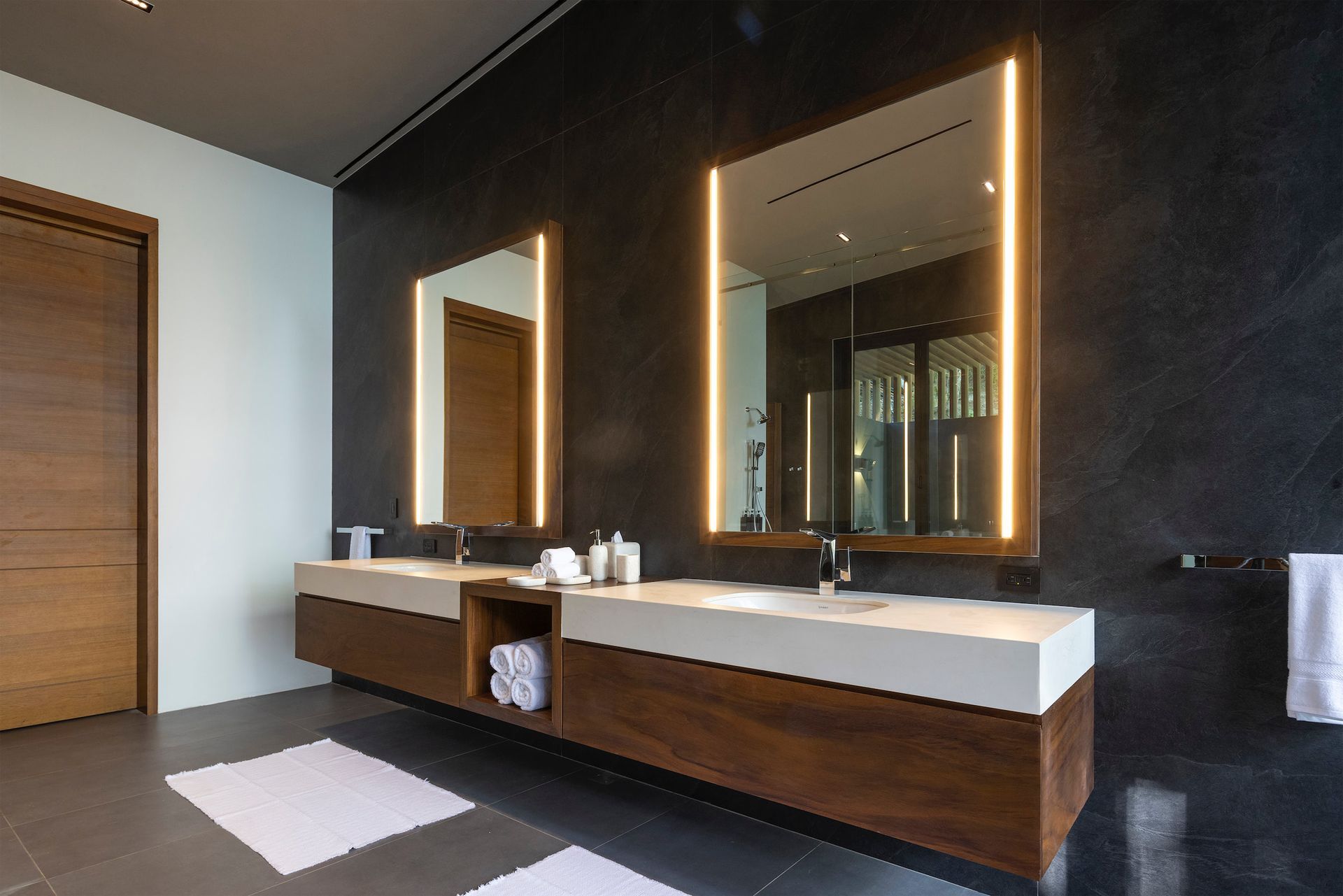 a bathroom with two sinks and two mirrors