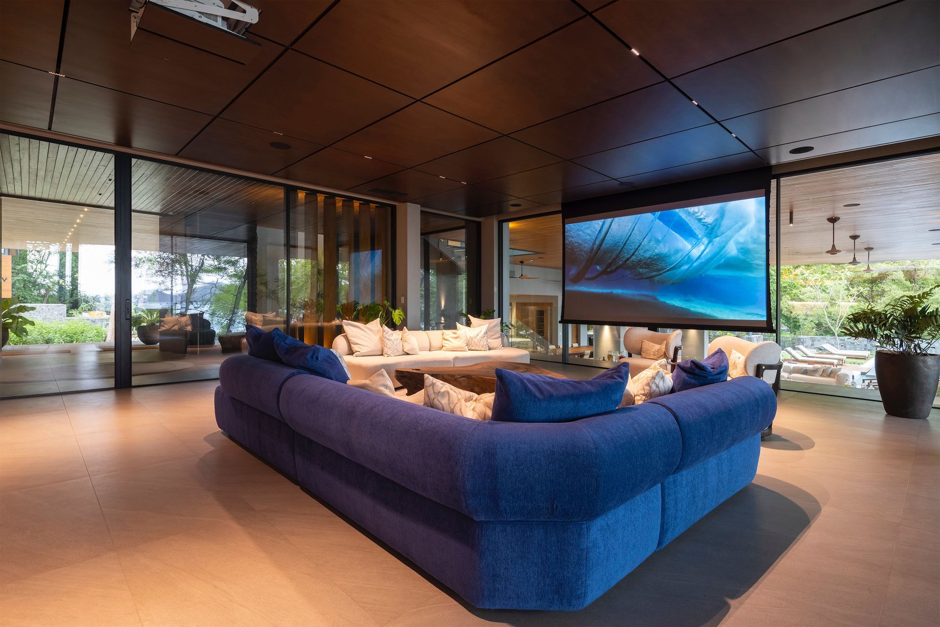 a living room with a large blue couch and a projector screen .