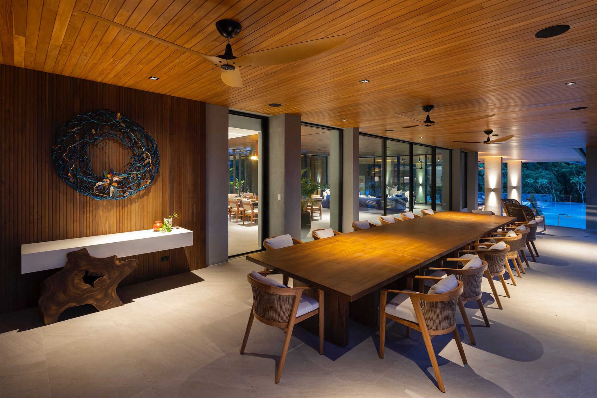a long wooden table and chairs in a room with a wooden ceiling .