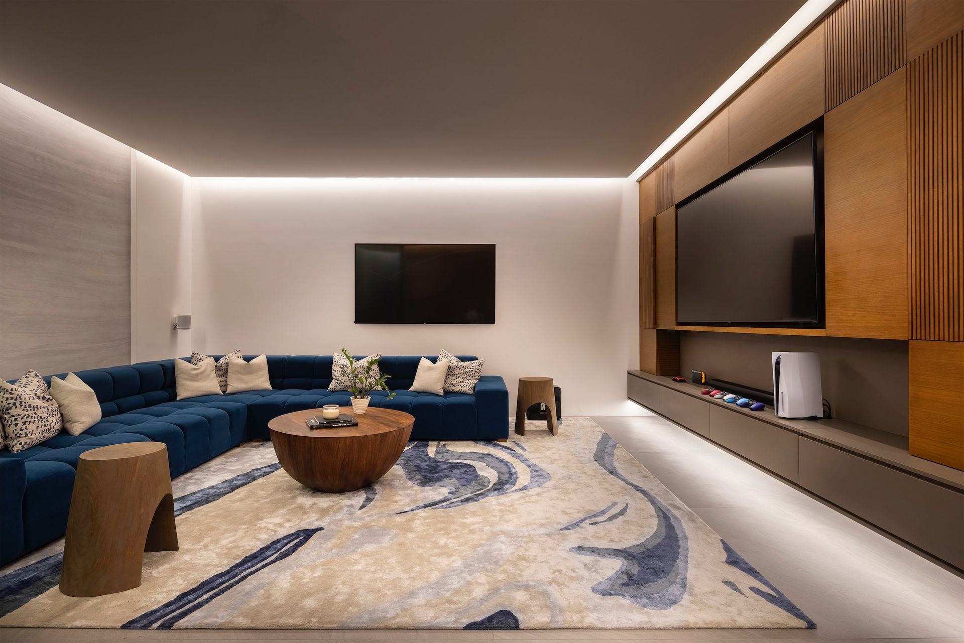 a living room with a large sectional couch and a flat screen tv .