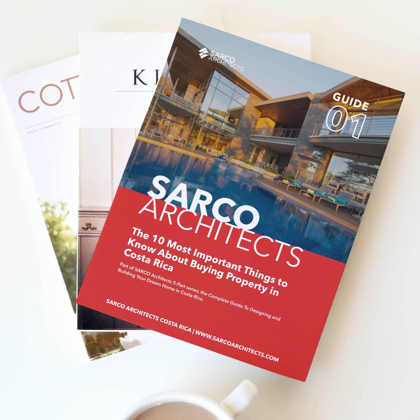 a book titled sarco architects sits on a table next to a cup of coffee
