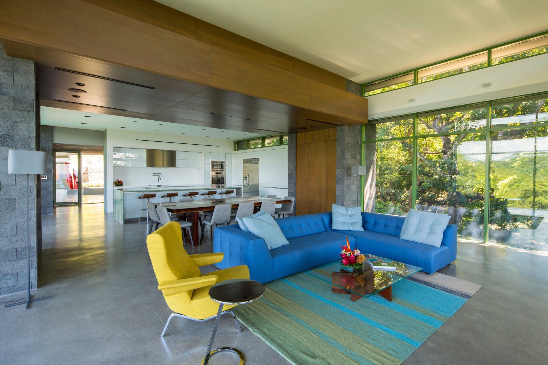 a living room with a blue couch and yellow chairs