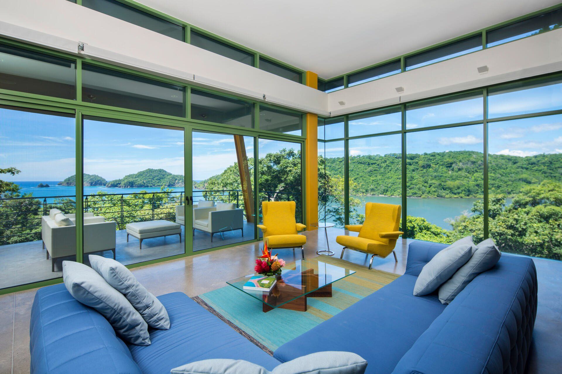 a living room with a blue couch and yellow chairs