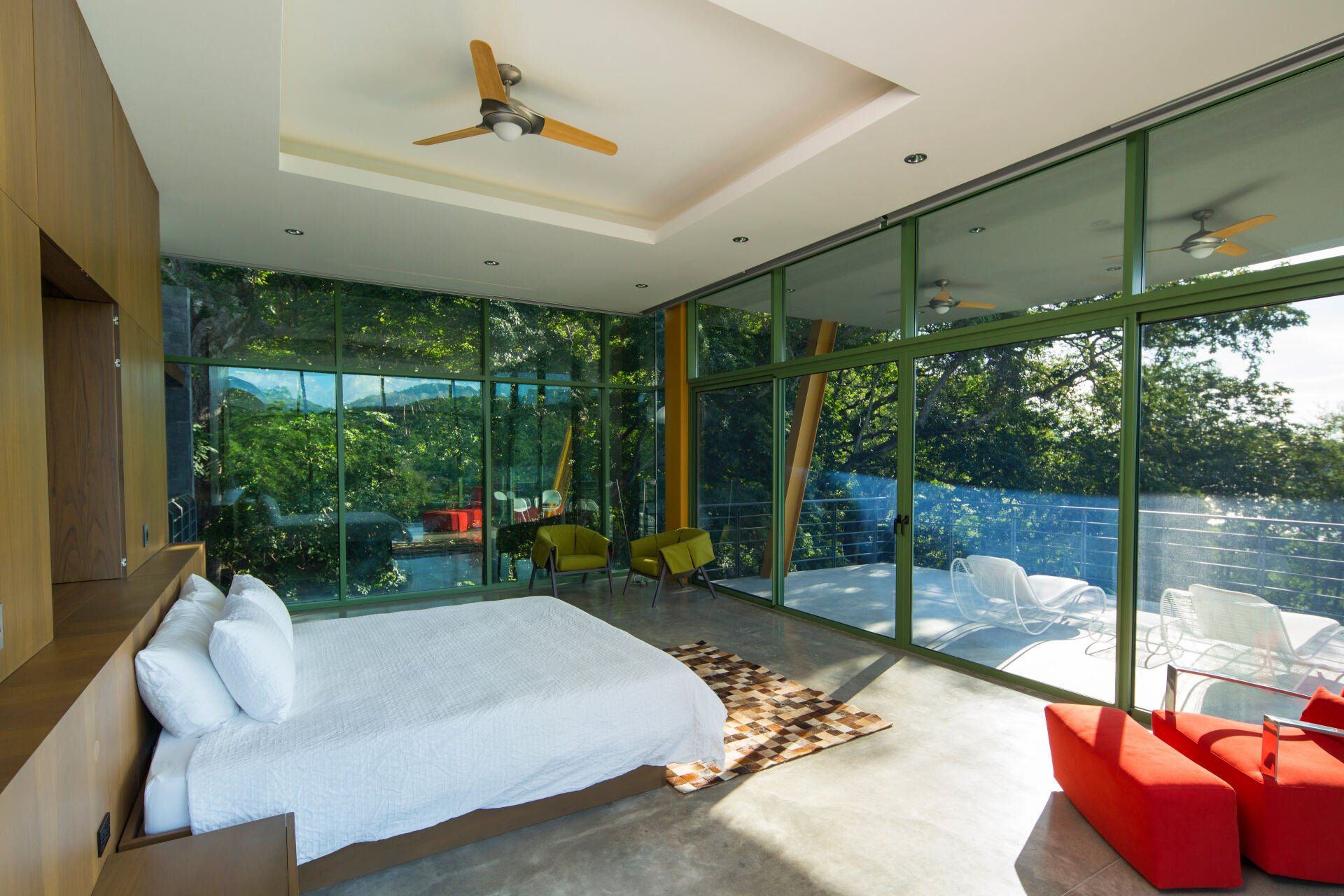 a bedroom with a large bed and lots of windows