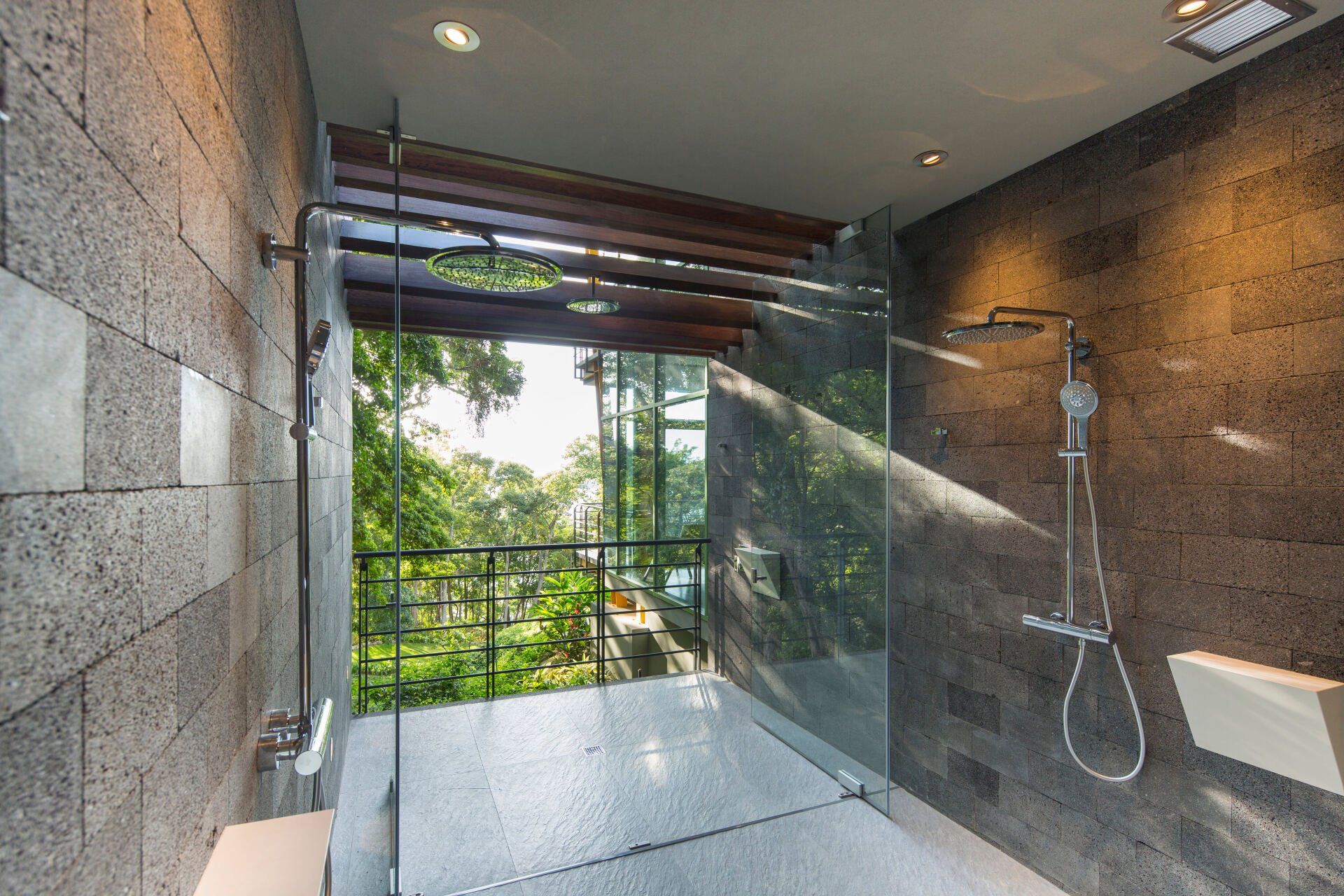 a bathroom with a walk in shower and a view of the trees .