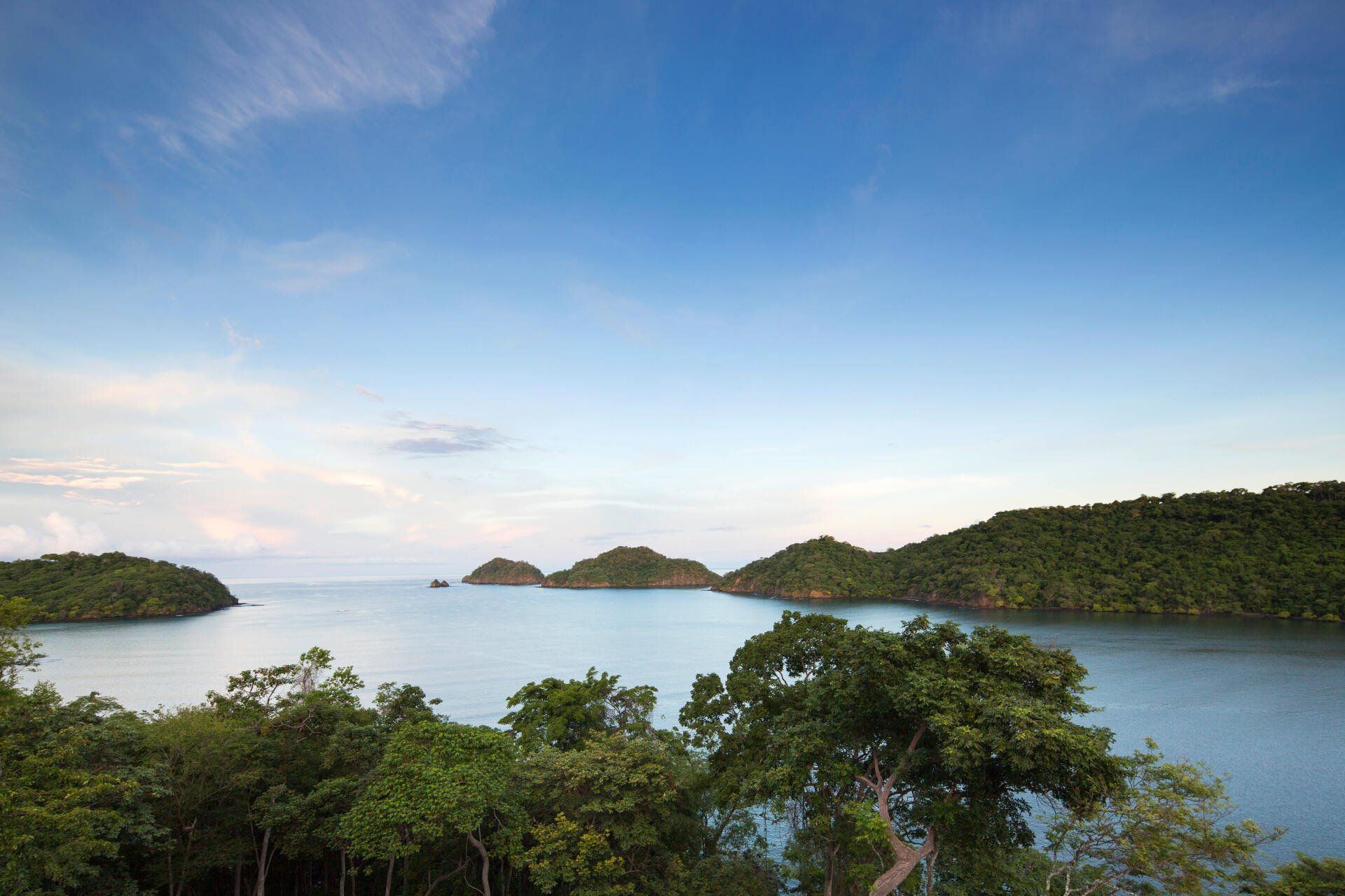 a large body of water surrounded by trees and mountains .