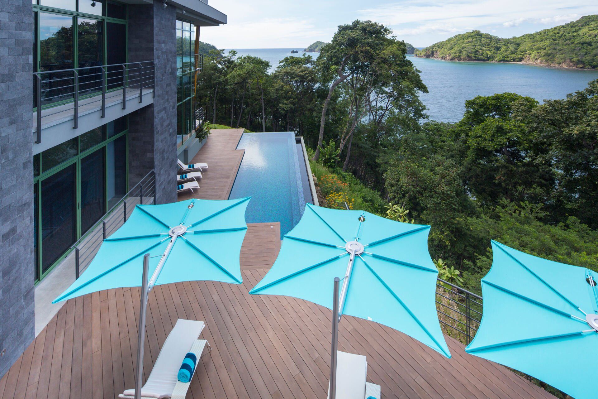 a large house with a swimming pool and umbrellas on the deck