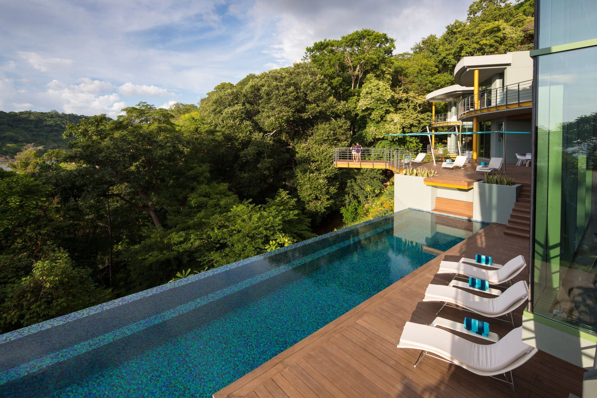a large swimming pool is surrounded by chairs and trees .
