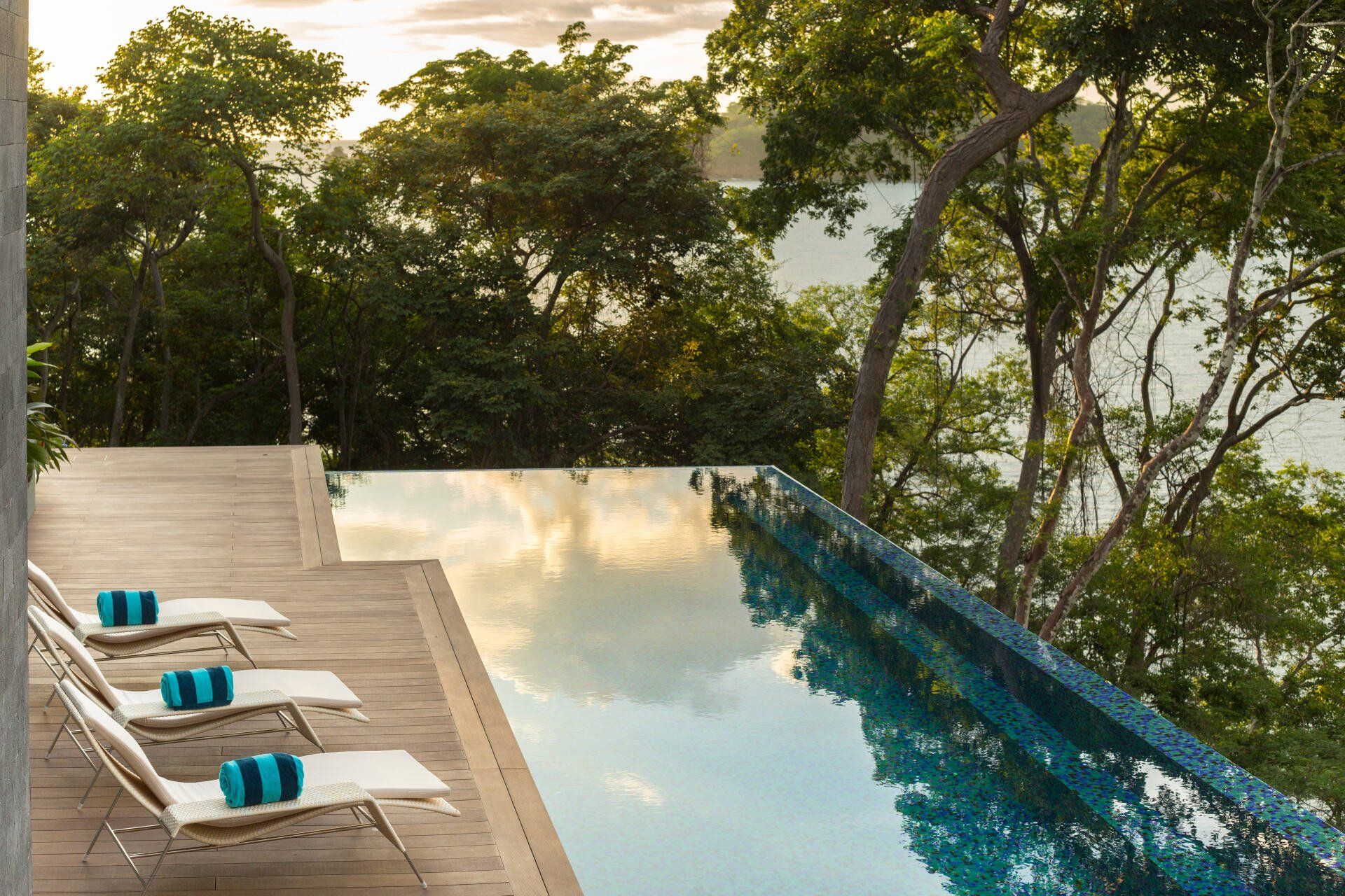 a large swimming pool surrounded by trees and chairs