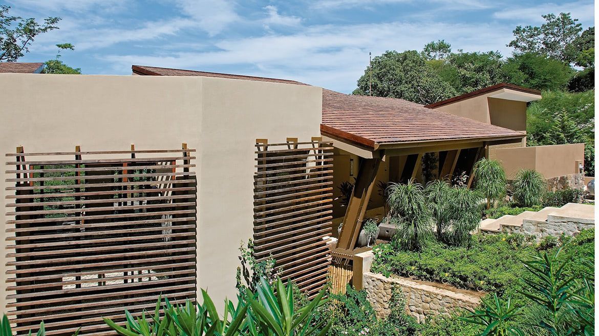 a house with a wicker fence in front of it