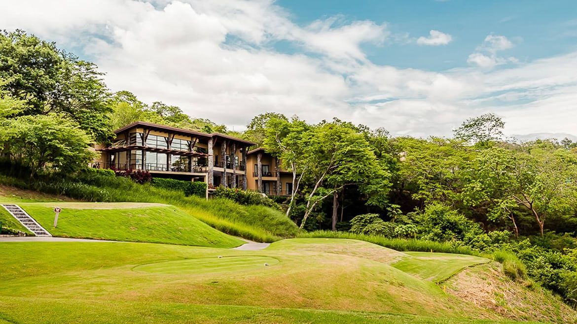 a large house is sitting on top of a hill surrounded by trees .