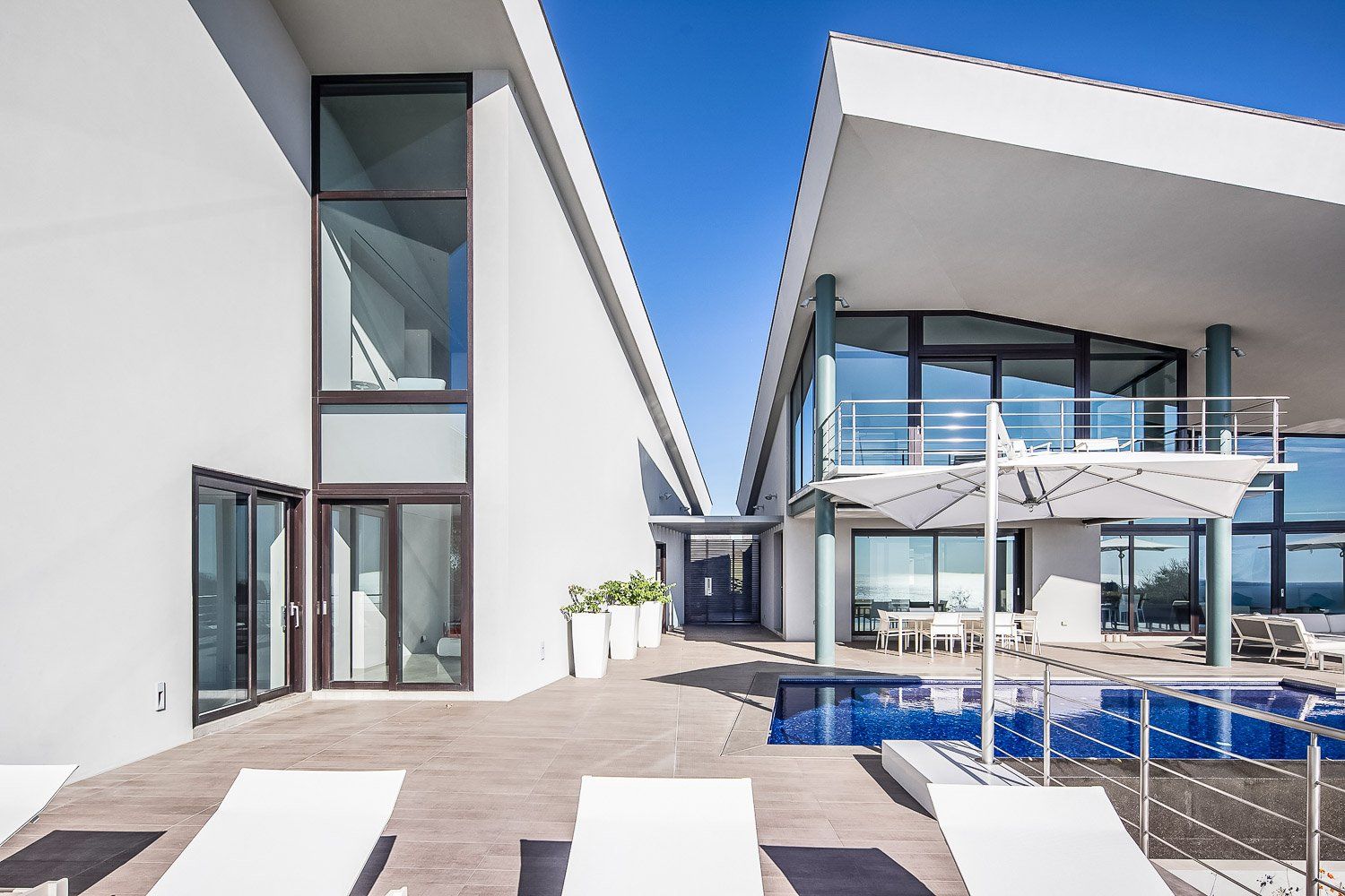 a large white house with a swimming pool in front of it