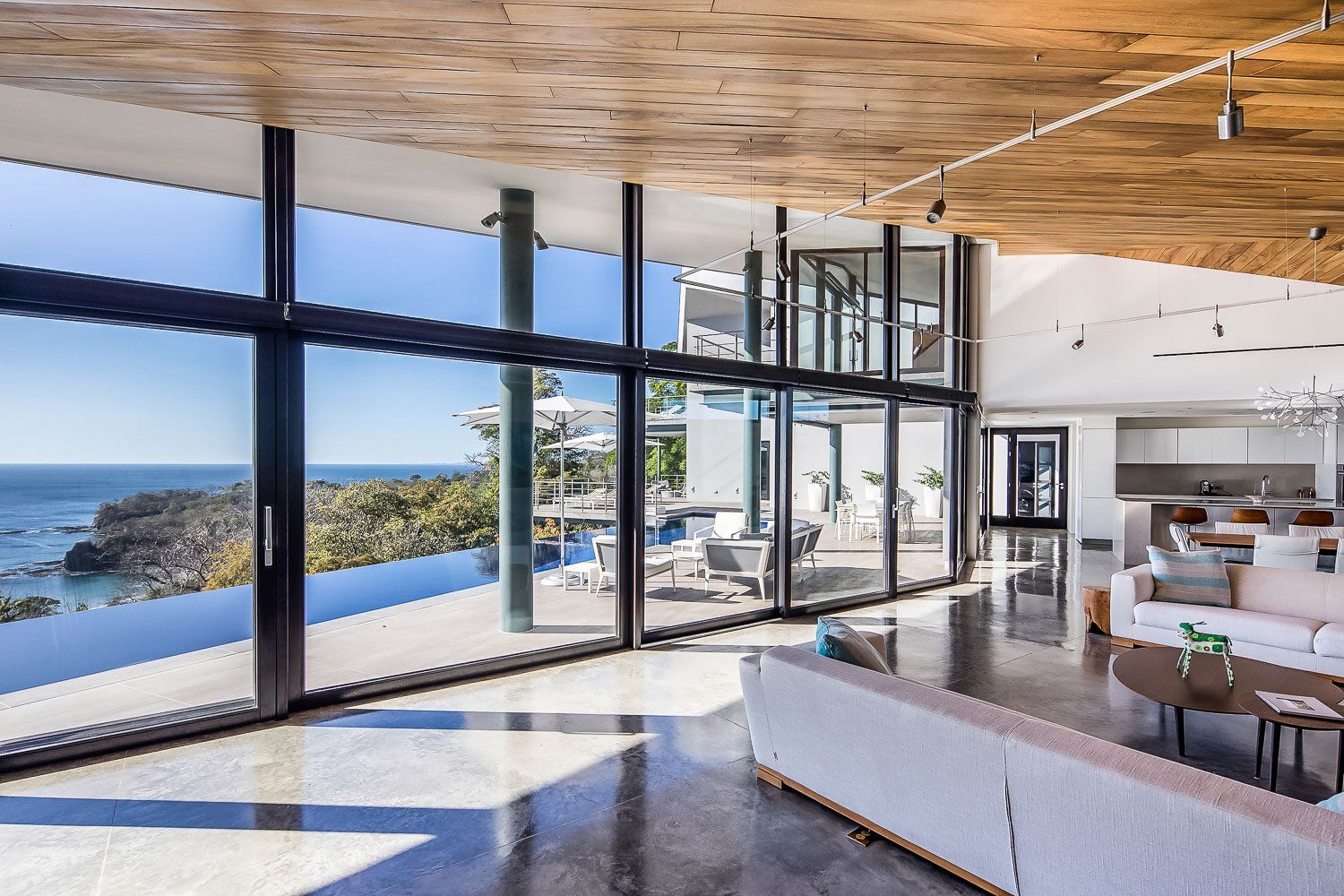 a living room with a lot of windows and a view of the ocean