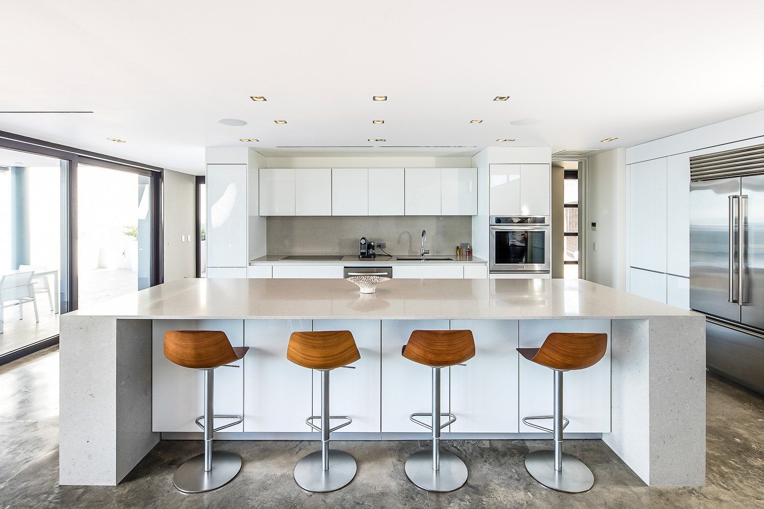 a kitchen with a large island and three bar stools