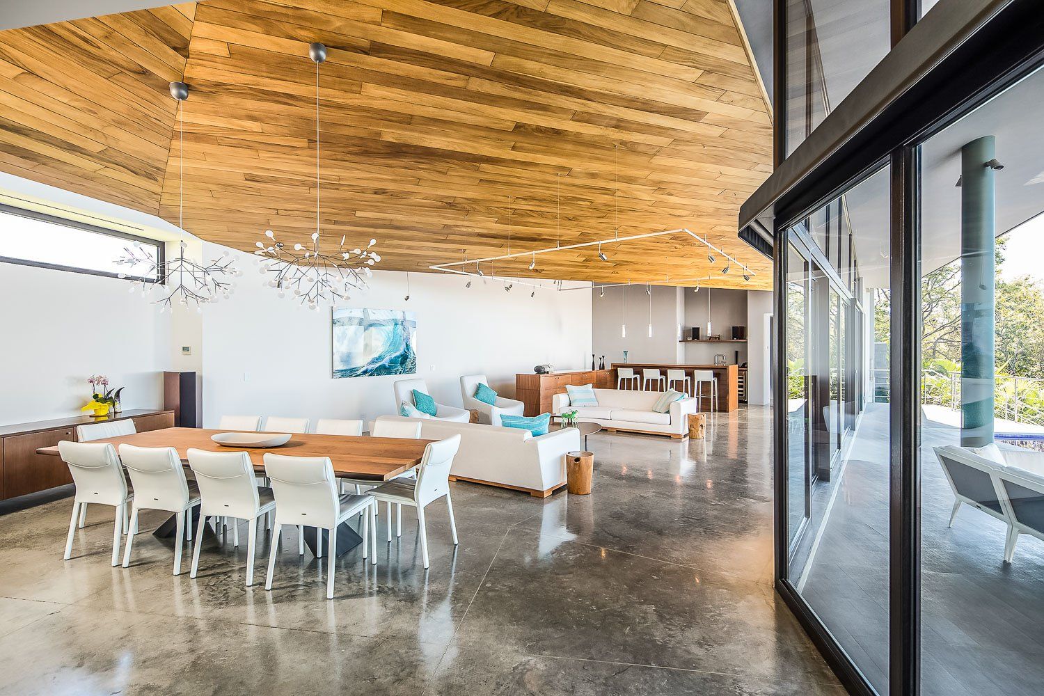 a large living room with a wooden ceiling and a dining table and chairs