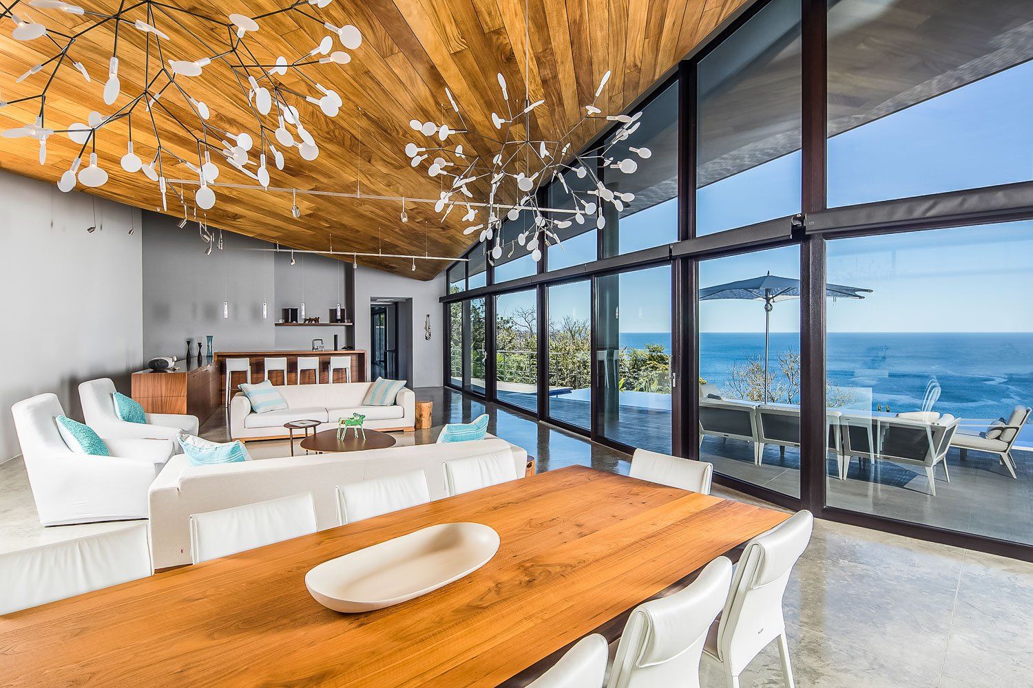 a living room with a wooden table and chairs and a view of the ocean .