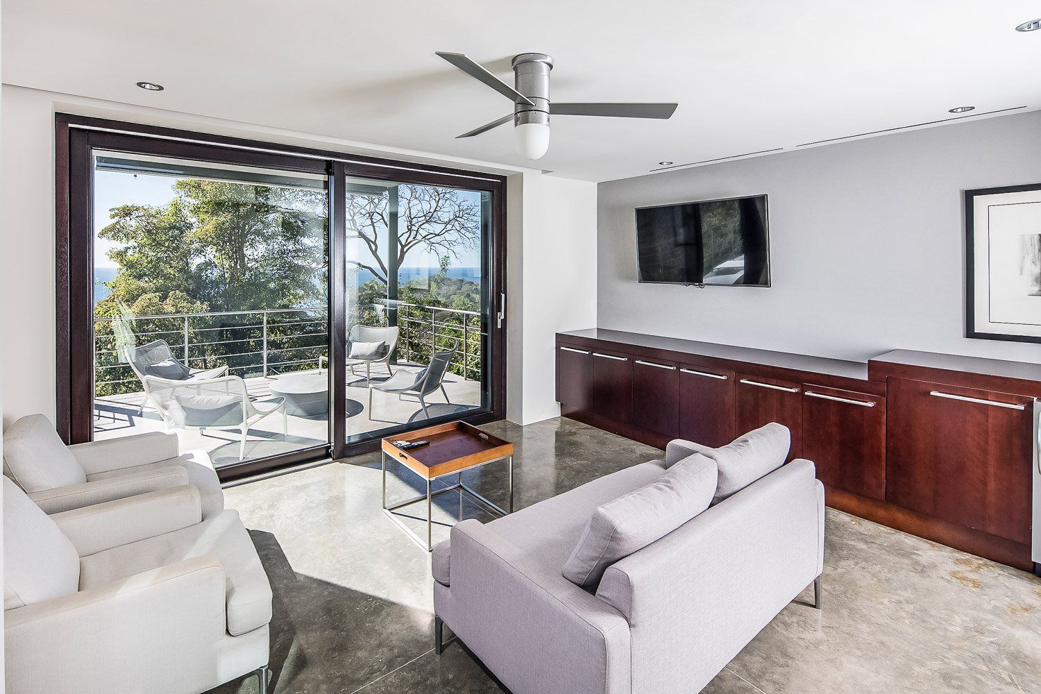 a living room with a couch and chairs and a ceiling fan
