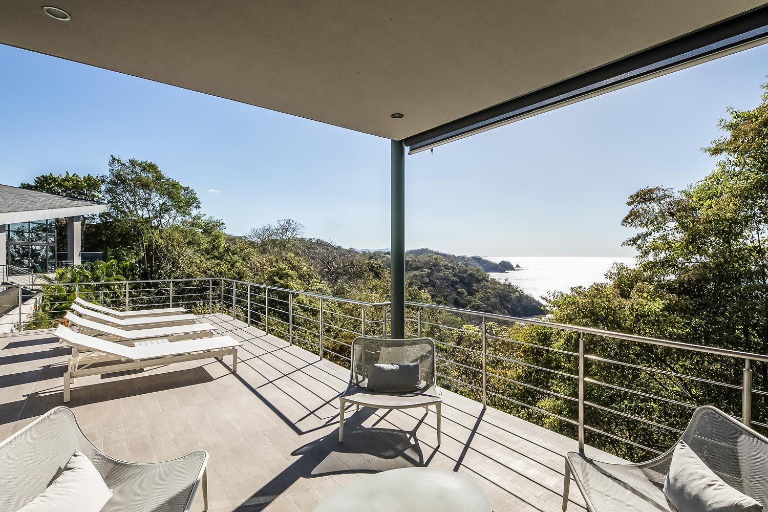 a balcony with a view of the ocean and trees