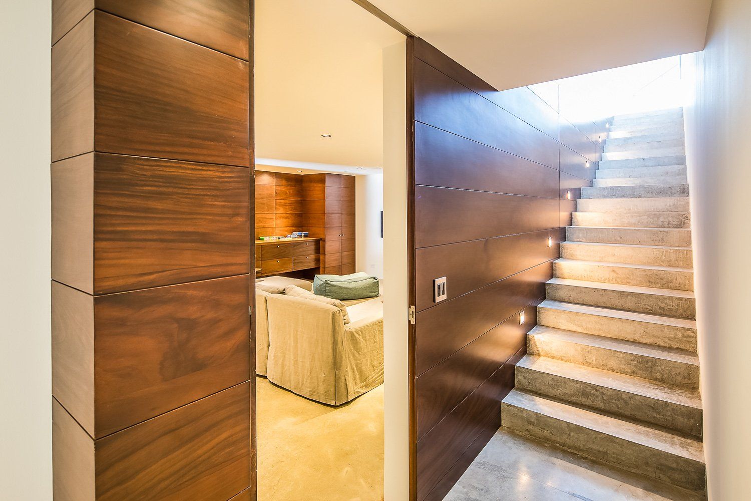a hallway with stairs leading up to a living room